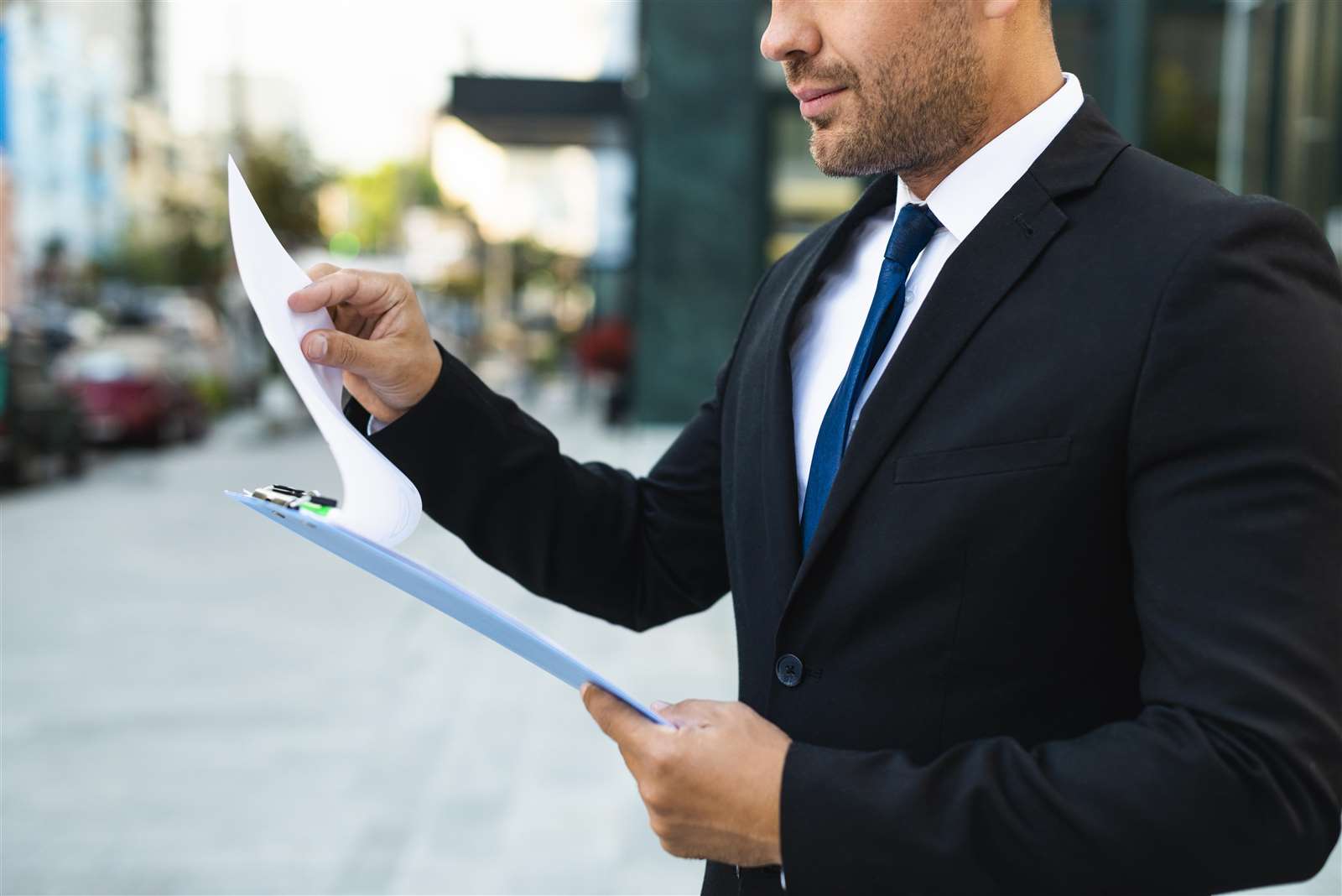 side-view-business-man-reading-from-clipboard